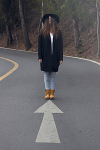 man standing at the middle of road beside forest thumbnail