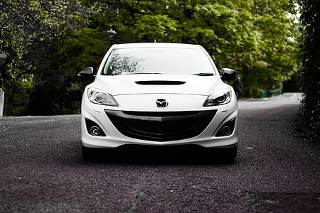 white Mazda car parked on road beside tree thumbnail