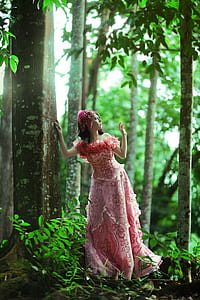woman wearing pink and red floral off-shoulder dress standing near tree thumbnail