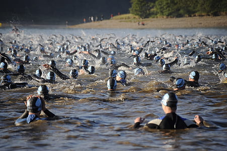 group of people swimming on body of water at daytime thumbnail