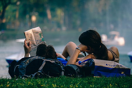 man and woman leaning on field with bags thumbnail
