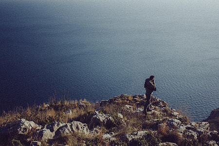 photo of man wearing jacket near body of water thumbnail