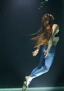 woman in blue-washed jeans and black brassiere swimming thumbnail