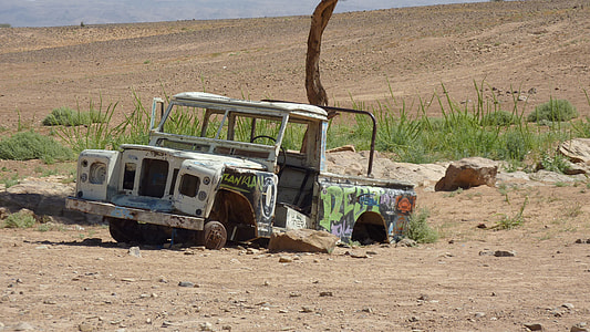 wrecked and abandoned white Land Rover Defender SUV on dessert during daytime thumbnail