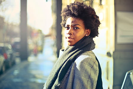 A young African woman with curly hair posing outdoors thumbnail
