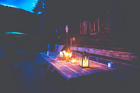 lightened candle inside candle holder on brown wooden table thumbnail