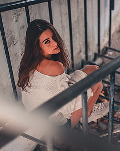 Woman Sits on Black Metal Railing Taken thumbnail