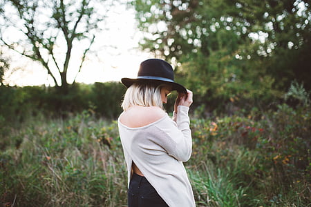 woman wearing black hat standing on green grass thumbnail