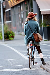 person wearing blue jacket riding bicycle during daytime thumbnail
