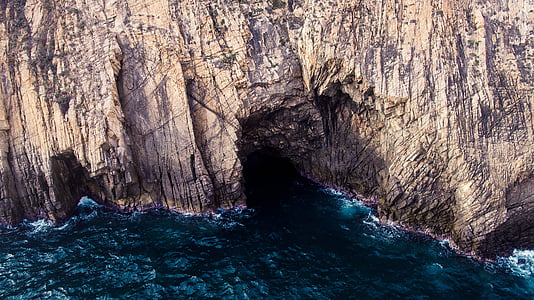 aerial view photography of cave near body of water thumbnail