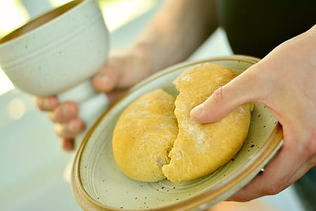 person holding saucer with baked bread thumbnail