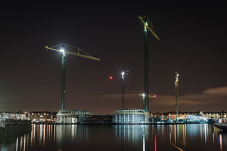 tower cranes near body of water thumbnail