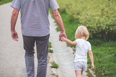 man holding the hand of girl walking on road thumbnail
