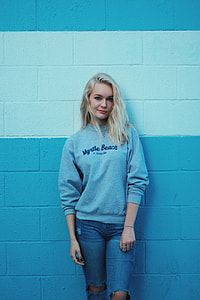 woman leaning on blue and white wall thumbnail