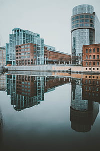 photo of high-rise buildings reflecting on calm body of water thumbnail