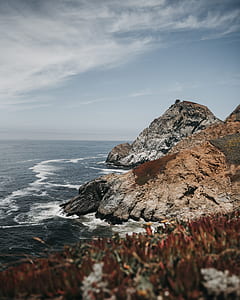 brown and gray mountain near the body of water during daytime thumbnail
