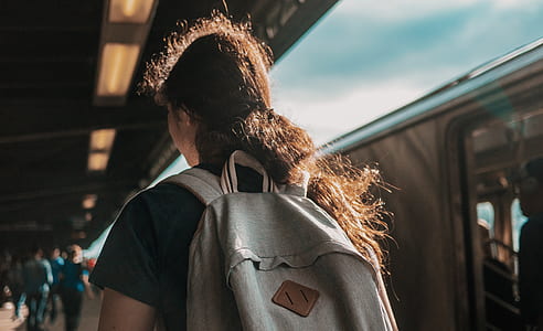 person wearing backpack standing beside train thumbnail