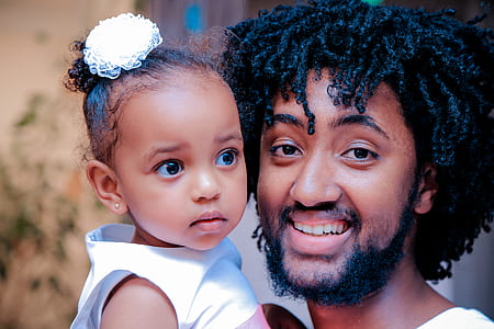 shallow focus photography of smiling man carrying girl thumbnail