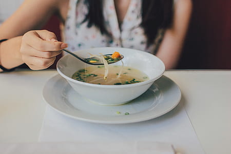 woman holding spoon with noodle soup thumbnail