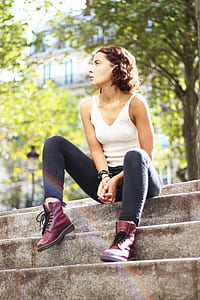 woman in white sleeveless top sitting on stairs during daytime thumbnail