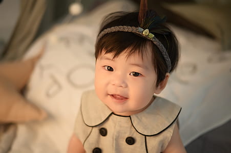 shallow focus photography of baby in gray sleeveless top thumbnail