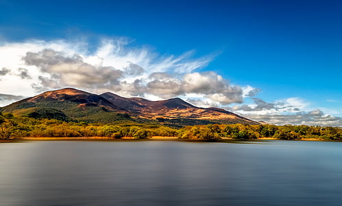 photo of island with mountain under blue sky thumbnail