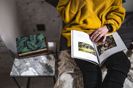 Young woman reading a magazine in bed thumbnail