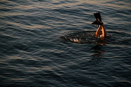 person swimming on body of water thumbnail