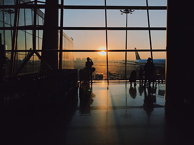 silhouette of building with glance of airplane outside during golden hour thumbnail
