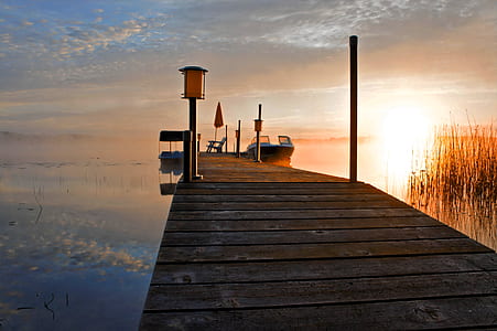 orange and white powerboat near brown wooden dock thumbnail