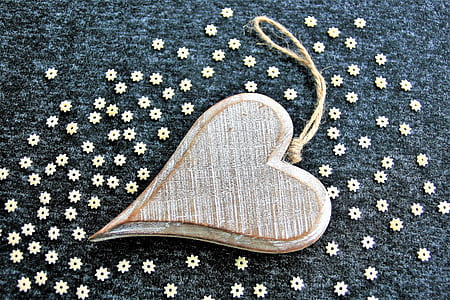 brown wooden heart hanging decor on black textile with white flowers thumbnail