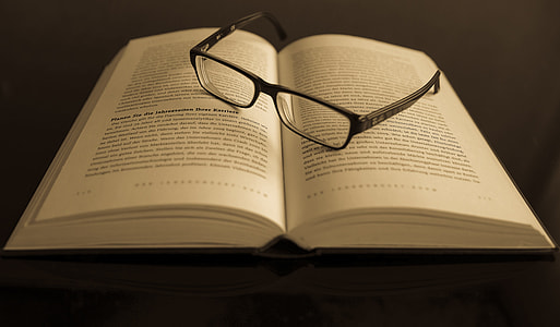 photo of black plastic frame eyeglasses on top of opened book thumbnail