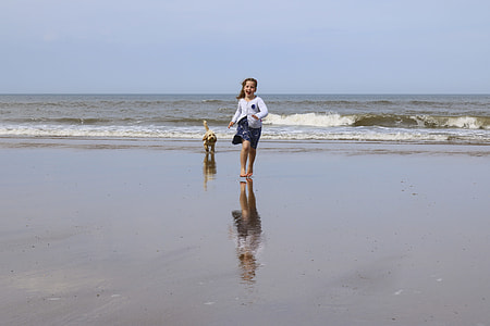girl in white crew-neck shirt running on seashore thumbnail