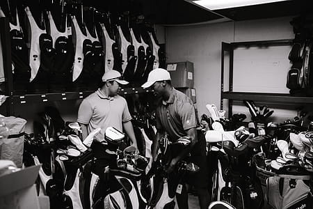 Grayscale Photography Of Men Surrounded By Golf Clubs thumbnail