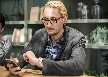 man sitting on chair while leaning on table thumbnail