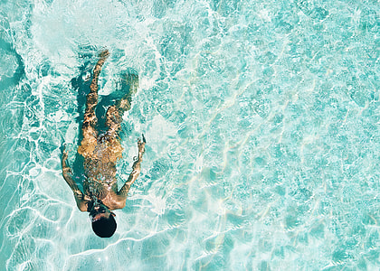 high angle photo of person swimming under body of water thumbnail