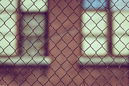 brown building structure behind gray steel chain link fence thumbnail
