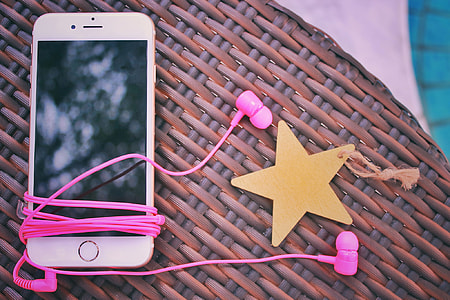 rose gold iPhone 6 with pink earphones on brown wicker table thumbnail