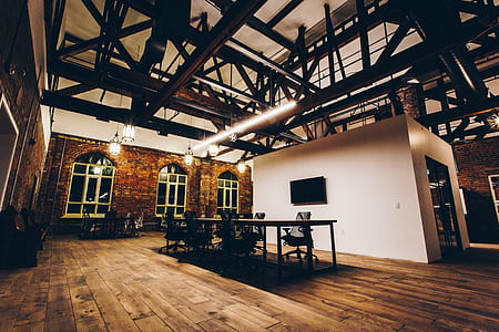 rolling chairs surrounding table under fluorescent lamp in spacious room thumbnail