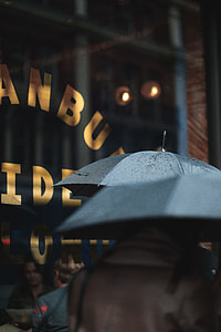 macro photography of people walking on street holding umbrella during rainy day thumbnail