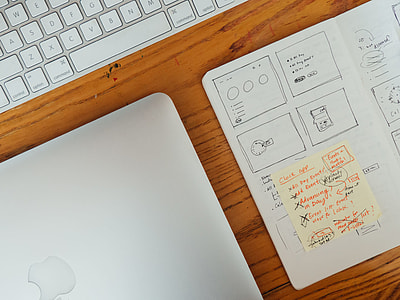 flat lay photography of closed silver MacBook beside Apple Wireless Keyboard and paper thumbnail