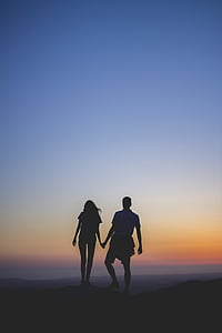 silhouette of couple on mountain edge during sunset thumbnail