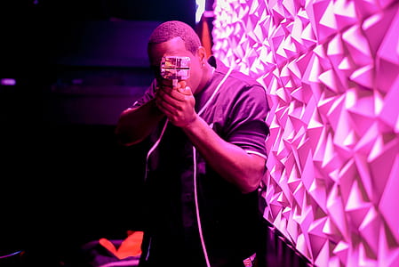 man holding action camera near pink wall thumbnail