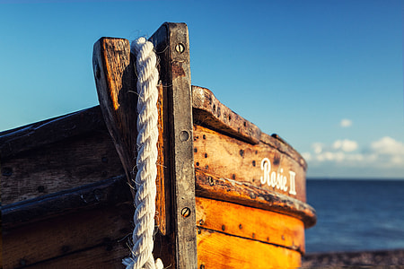 A wooden fishing boat rests on the beach on a sunny day in Deal in Kent, England thumbnail
