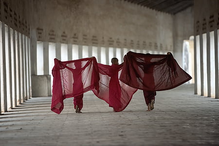three woman holding red textiles thumbnail