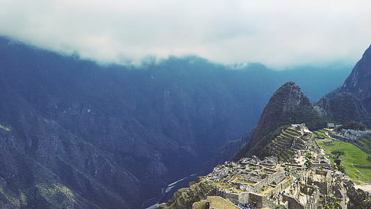 gray concrete buildings near mountains at daytime thumbnail