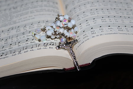 silver-colored crucifix pendant on book thumbnail