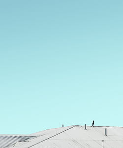 building with white roof under teal sky thumbnail