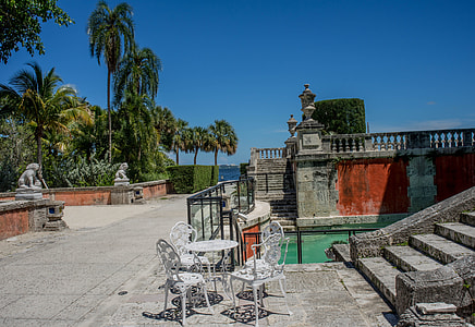 empty table with chairs beside swimming pool thumbnail