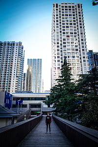 man standing on stairs taking photo with high-rise building background thumbnail